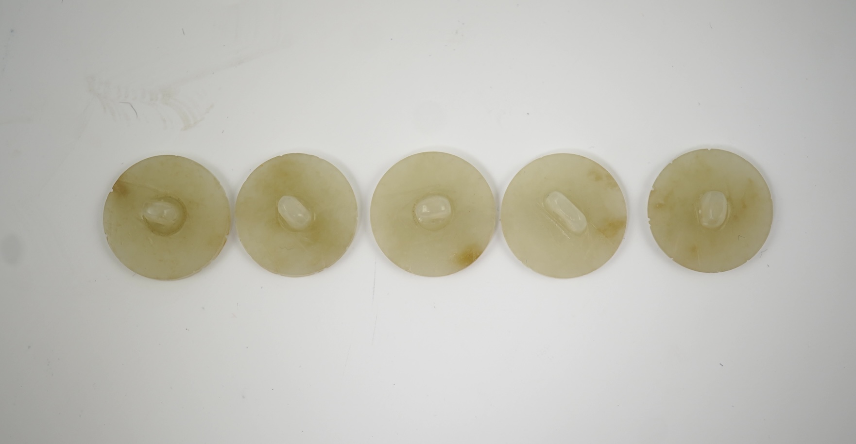 A set of five Chinese pale celadon jade robe buttons, 19th century